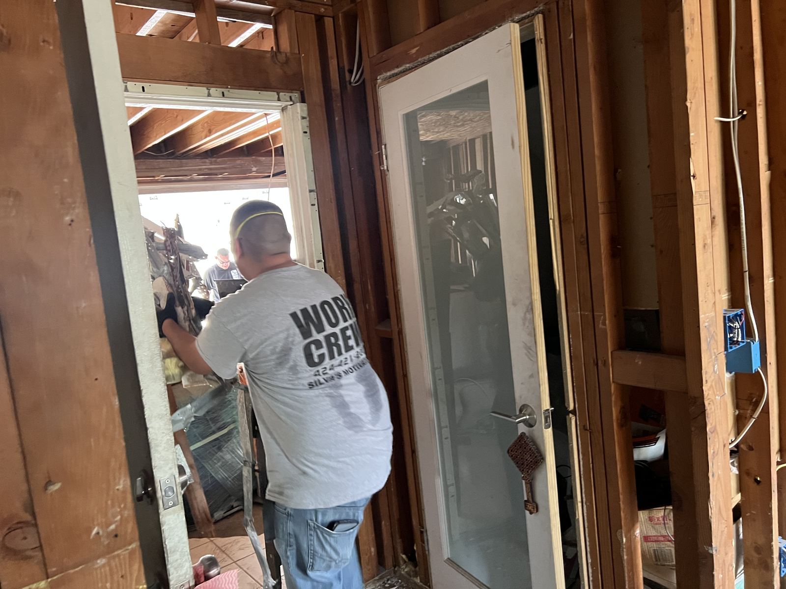 Work crew member carrying materials through a doorway on site